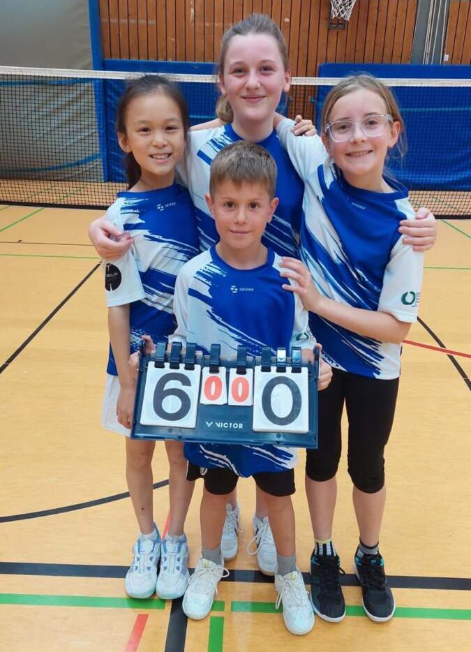 Vier Kinder der U11-1 der SG Bremthal/Fischbach in blau-weißen Trikots halten in der Halle eine Anzeigetafel mit dem Ergebnis 6:0