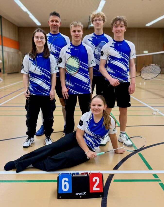 Sechs Spielerinnen und Spieler der Zweiten Mannschaft der SG Bremthal/Fischbach in blau-weißen Trikots mit Schlägern in der Halle, davor eine Anzeigetafel mit dem Ergebnis 6:2